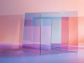 Rectangular panes of transparent material, tinted in soft pinks, blues, and oranges, overlap to create a layered, abstract composition.