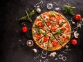 Pyszna pizza z pomidorkami, pieczarkami i bazylią. Zastanawiasz się, ile kcal ma pizza? To zależy od składników!