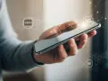 Hand holding a smartphone with "eSIM" and "5G" icons and network graphics.