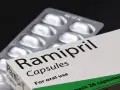 Ramipril kapsułki na nadciśnienie. Opakowanie leku i blister z tabletkami na czarnym tle.