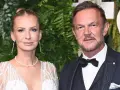 Cezary Pazura z żoną Edytą na ściance. Ona w białej, zdobionej sukni, on w eleganckim garniturze.