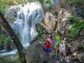 Niños exploran la Garganta de las Nogaleas, disfrutando de una cascada y la naturaleza.