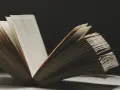 Un libro abierto revela páginas llenas de texto, evocando la sabiduría y las **frases en francés de la vida** que inspiran.