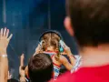 Une jeune fille aux tresses bleues porte un casque anti-bruit pour contrôler le niveau sonore d'un concert.