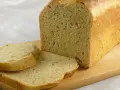 Frisch gebackenes Brot, das wie aus Buchweizen und anderen Getreidesorten gemacht aussieht, liegt auf einem Holzbrett.