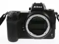 Czarny aparat Nikon Z7 III z obiektywem bez obiektywu, widoczny z przodu, z paskiem na nadgarstek.