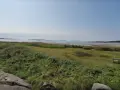 En bänk vid Rågelunds camping bjuder in till en stunds avkoppling med utsikt över vatten och grönska.