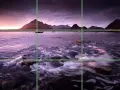 Paysage marin au crépuscule, avec des montagnes en arrière-plan et des bateaux sur l'eau. La composition suit la règle des tiers pour un équilibre visuel.