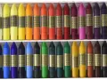 Ceras Manley de colores variados en una caja, dispuestas en dos filas.