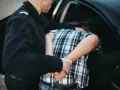 Policjant zakłada kajdanki zatrzymanemu młodemu mężczyźnie. Od ilu lat ponosi się odpowiedzialność karna?