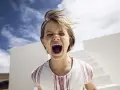 Kind schreit laut, Haare wehen im Wind. Ein Moment, der an einen affektive Dysregulation test erinnert.