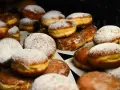 Puszyste pączki z piekarnika, niektóre oprószone cukrem pudrem, inne błyszczące od lukru. Idealne na tłusty czwartek!