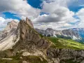 Majestatyczne szczyty Dolomitów w Val Gardena, zielone zbocza i malownicza ścieżka dla turystów.