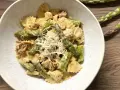 Pyszne makaron farfalle ze szparagami i kurczakiem w kremowym sosie, posypany startym parmezanem.