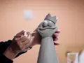 Manos trabajando con arcilla para crear una figura de rana con corona.