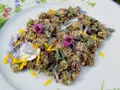 Get inspired for rotklee rezepte! Getrocknete Rotklee-Blüten und Blütenblätter auf einem Teller, garniert mit kleinen lila und gelben Blüten.