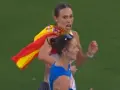 Laura García Caro celebra su victoria en atletismo, ondeando la bandera española con orgullo.