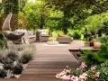 Un rincón acogedor con muebles de mimbre, una hamaca colgante y flores, ideal para disfrutar de pequeños jardines.