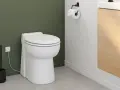 Toilettes modernes avec un sanibroyeur discret, dont le fonctionnement est assuré par une prise électrique visible.