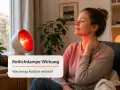 Frau genießt die wohltuende Rotlichtlampe Wirkung am Nacken. Die Wärme entspannt und lindert Verspannungen.
