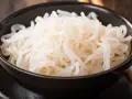 Misternie ułożony makaron konjac w czarnej misce, gotowy do spożycia z pałeczkami.