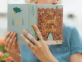 Kobieta czyta "Sekretny ogród", klasyczną literaturę, która inspiruje do odkrywania piękna natury.
