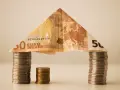 Dom z banknotu 50 euro i monet. Symbolizuje, kiedy umowa pożyczki jest nieważna, a pieniądze mogą się rozpłynąć.