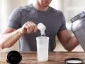 Hombre preparando un batido. Sabe cuándo tomar BCAA para optimizar su entrenamiento.