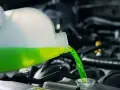 Versamento di liquido refrigerante verde in un radiatore. Le cause di un radiatore senza acqua possono essere perdite o evaporazione.