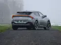 Szare Kia EV6 GT z żółtymi zaciskami hamulcowymi na tle mglistego krajobrazu.