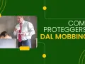 Uomo con tazza osserva donna stressata al pc. Colleghi che vogliono farti licenziare? Proteggersi dal mobbing.