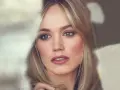 Kobieta z blond włosami i wysokim czołem, patrząca w bok z zamyśleniem.