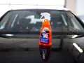En flaska SONAX Xtreme Ceramic Wet Coat står på en våt bilhuv.