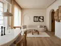 Un soggiorno in stile wabi sabi con divano curvo, tavolino in legno grezzo, tappeto soffice e decorazioni minimaliste.