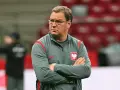 Trener reprezentacji Polski w piłce nożnej, z założonymi rękami, w okularach, zastanawia się, ile zarabia.