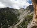 Un sentiero serpeggia tra montagne rocciose e vegetazione rigogliosa, un'avventura estiva al passo lanciano.