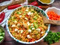 Frischer bulgursalat mit feta, Tomaten, Paprika und Frühlingszwiebeln, garniert mit Petersilie.