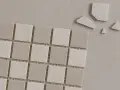 Små, ljusa mosaikplattor i grå och vita nyanser, några trasiga bitar ligger bredvid. Perfekt för att torka papper eller skapa ett mönster.