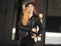 Dziewczyna w czarnej ramonesce i czapce, emanująca pewnością siebie w stylu glam rock.