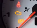 Kontrolka check engine świeci się. Czy można jeździć? Na desce rozdzielczej widać też kontrolki pasów i poduszek powietrznych.