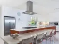 Cocina moderna con isla, electrodomésticos de acero inoxidable y encimera de cuarzo. Ideal para calcular el reforma cocina precio aproximado.