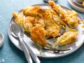 Piatto di fiori di zucca in pastella dorati e croccanti, serviti con sale grosso e posate.