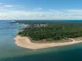 Widok na zatokę pucką z lotu ptaka. Widać piaszczystą plażę, las sosnowy, miasteczko z portem i latarnię morską.