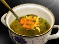 Łyżka nabiera aromatyczny bulion z marchewką i makaronem. Idealny przepis, jak zrobić bulion, który rozgrzeje serce.