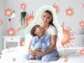 Mama tuli dziecko, które miało kaszel w nocy. Wokół nich wirusy, ale chroni je zielona bariera.