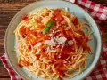 Pyszne spaghetti z sosem pomidorowym, parmezanem i bazylią. Czy to Makaron Barilla czy De Cecco? Trudno odróżnić!