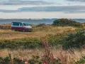 Husbil parkerad vid en kustväg i Danmark, redo för ett äventyr. En perfekt roadtrip danmark-upplevelse.