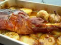Paletilla de cordero asada al horno con patatas y ajos.