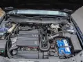 Silnik V6 wolnossący Peugeot, z widocznym akumulatorem Varta i elementami układu dolotowego.