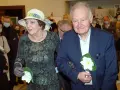 Ewa Dałkowska z synem Ksawerym, elegancko ubrani, z kwiatami w dłoniach, podczas uroczystości.